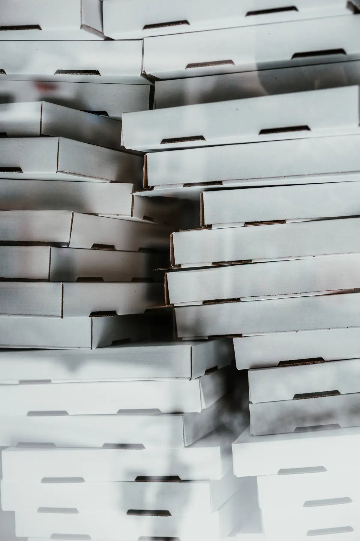 Übereinander gestapelte Pizzakartons von Pizzabox24 in hervorragender Qualität in Weiß unbedruckt, mit Standardmotiv oder mit eigenem Logo. Günstig und schnell geliefert